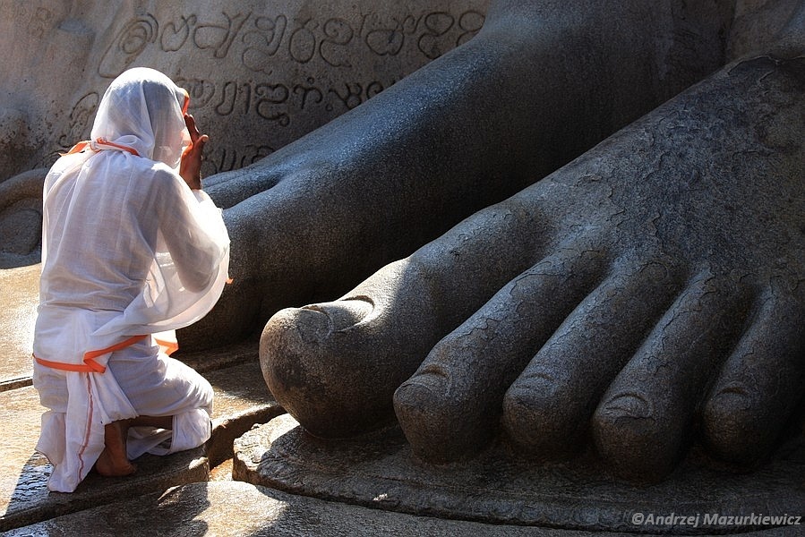 Mnich modlący się przed posągiem Gomateśwary w Śravanbelagoli